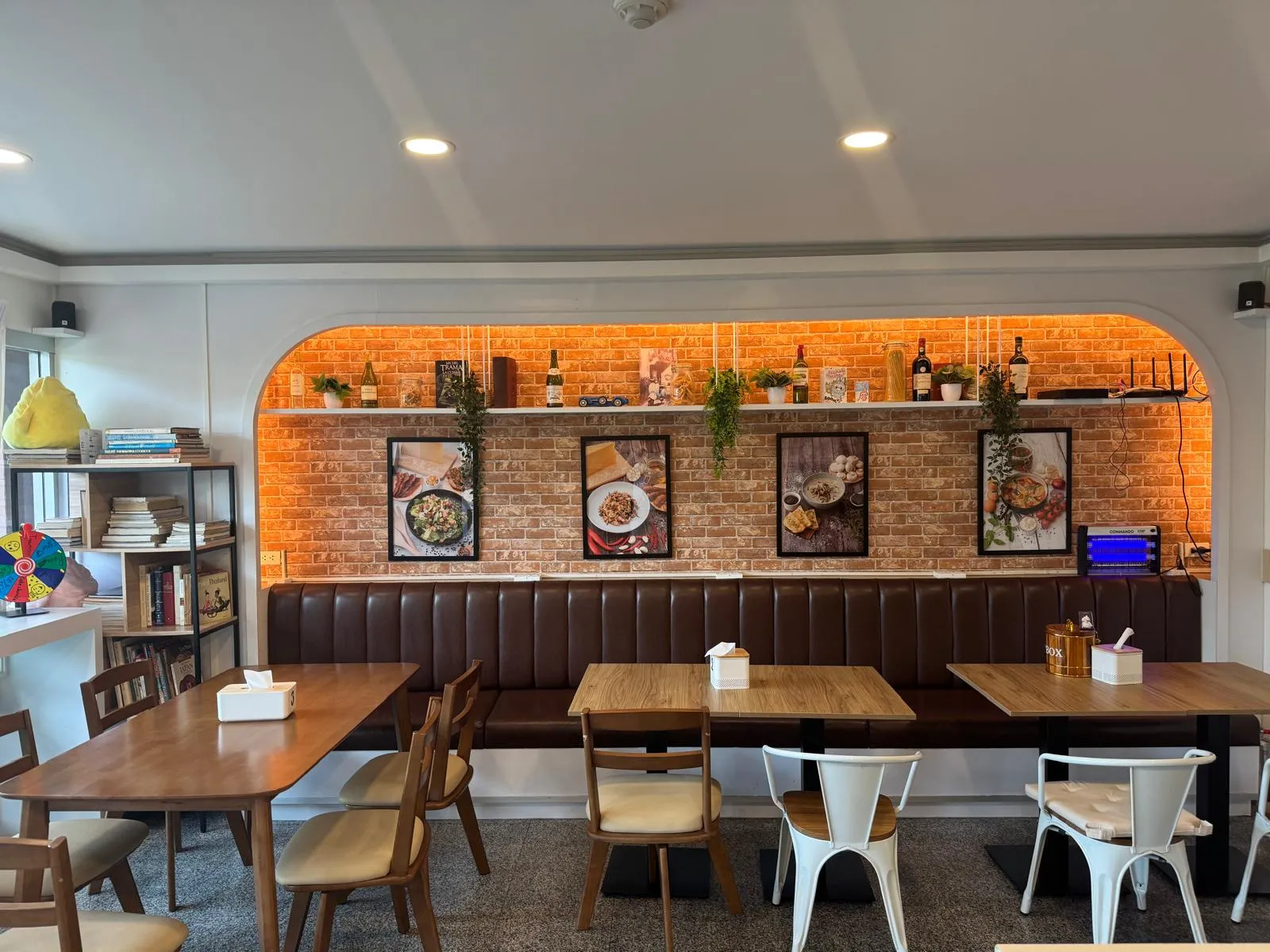 Salle de Chez Max — banquettes en cuir brun, mur en briques, éclairage chaud
