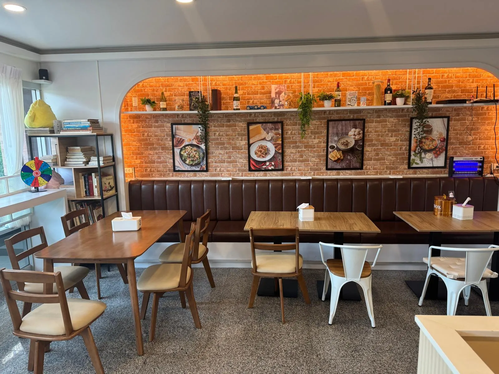 Salle de Chez Max : arche en briques, cadres gastronomiques, banquettes en cuir brun